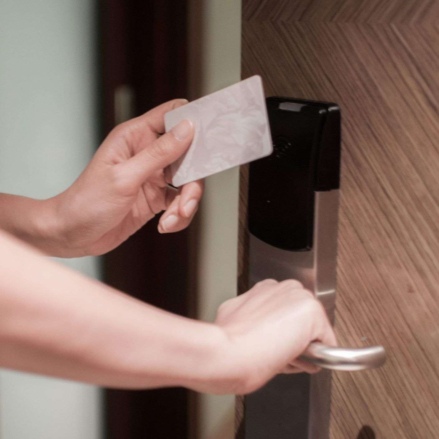 Person using keycard to unlock door.